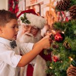 Santa and young boy decoration Christmas tree at Santa Sessions by Gary Evans Photography